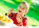 little-girl-sits-at-a-table-on-a-verandah-and-eats-fresh-vegetables-51130768-thumbnail