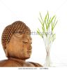 wooden-buddha-with-eyes-closed-in-prayer-and-bamboo-leaf-grass-with-reflection-in-rippled-grey-41779801-thumbnail